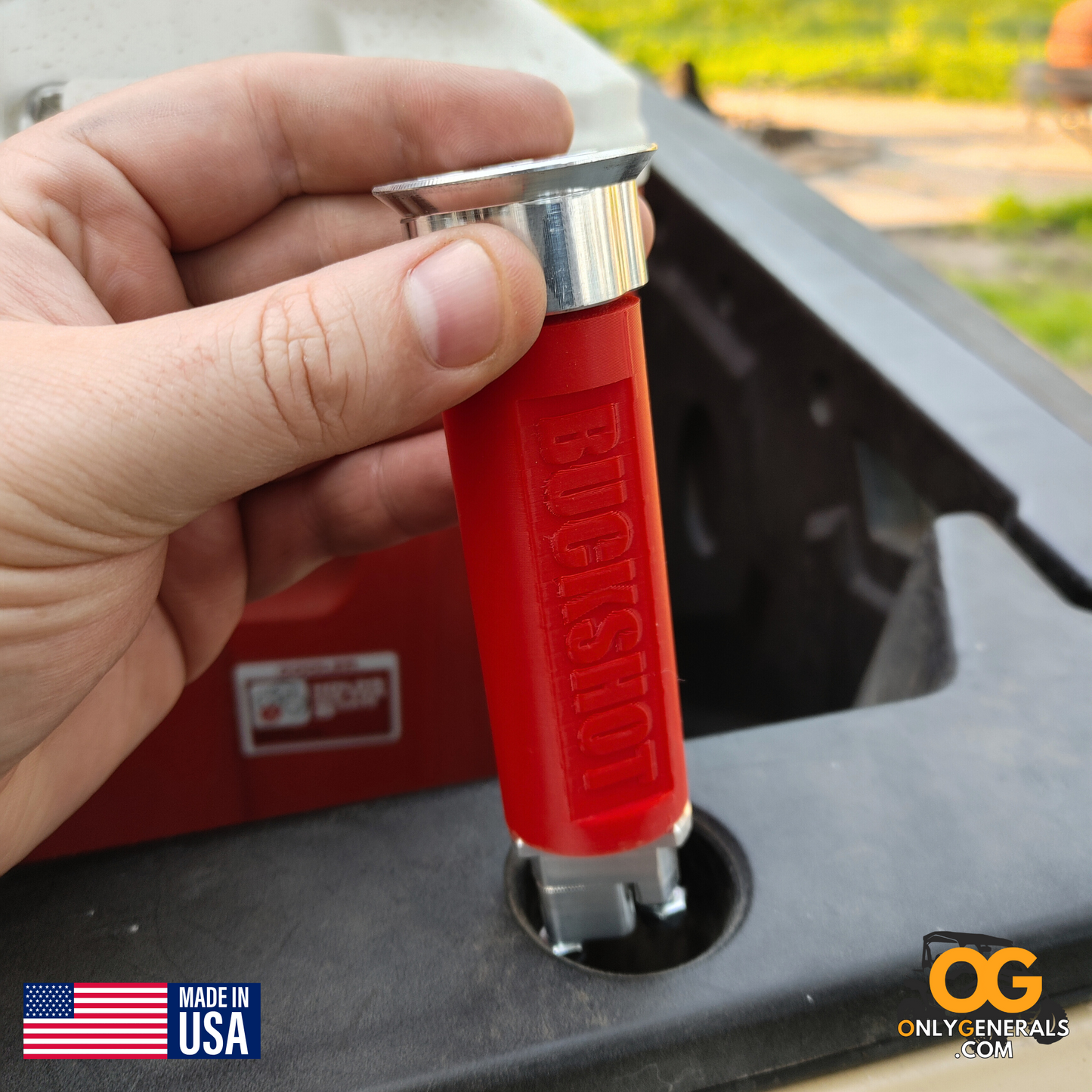 A hand loading a BUCKSHOT bed anchor into the lock & ride bed rail of a Polaris General
