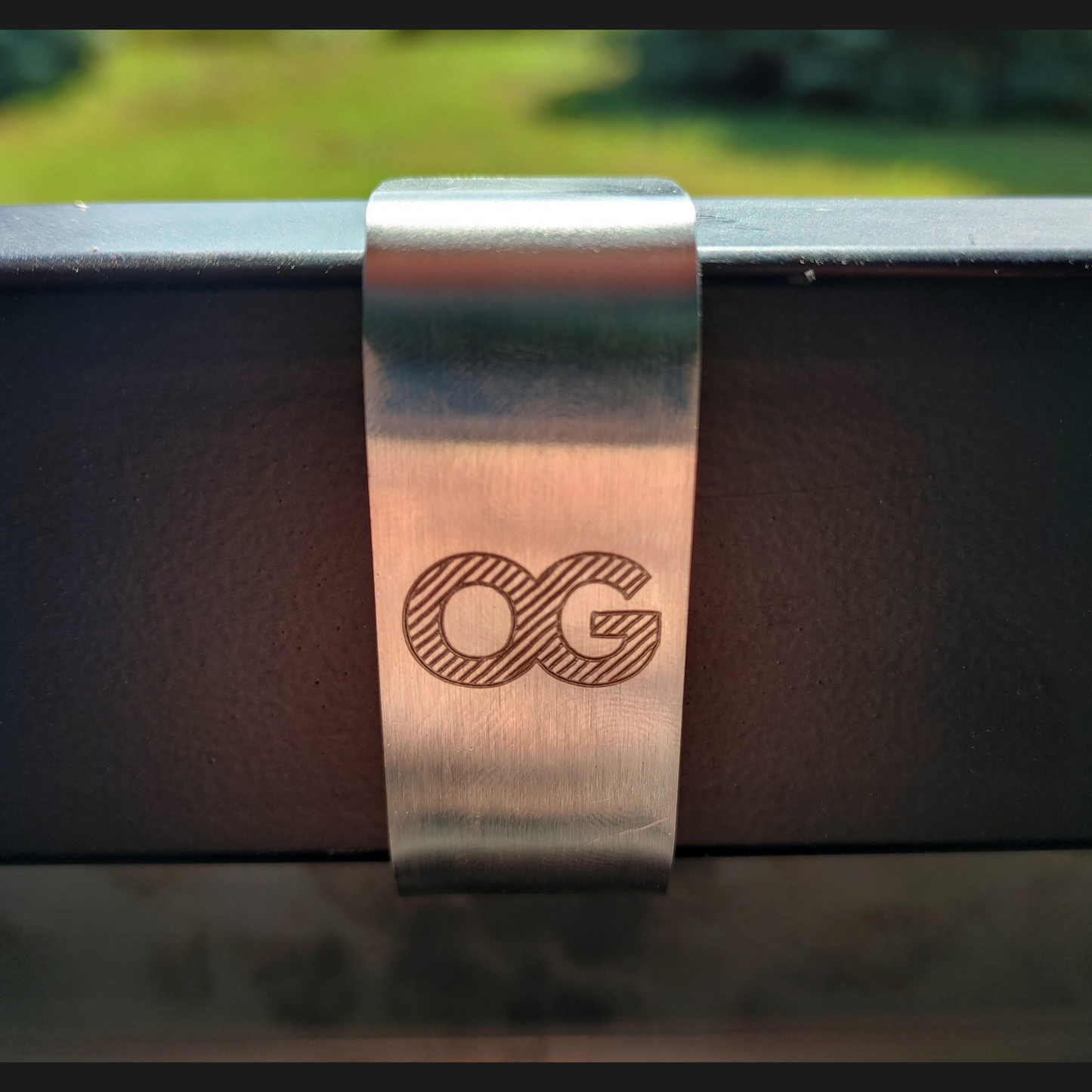 Laser etched OG logo on a stainless steel mounting bracket