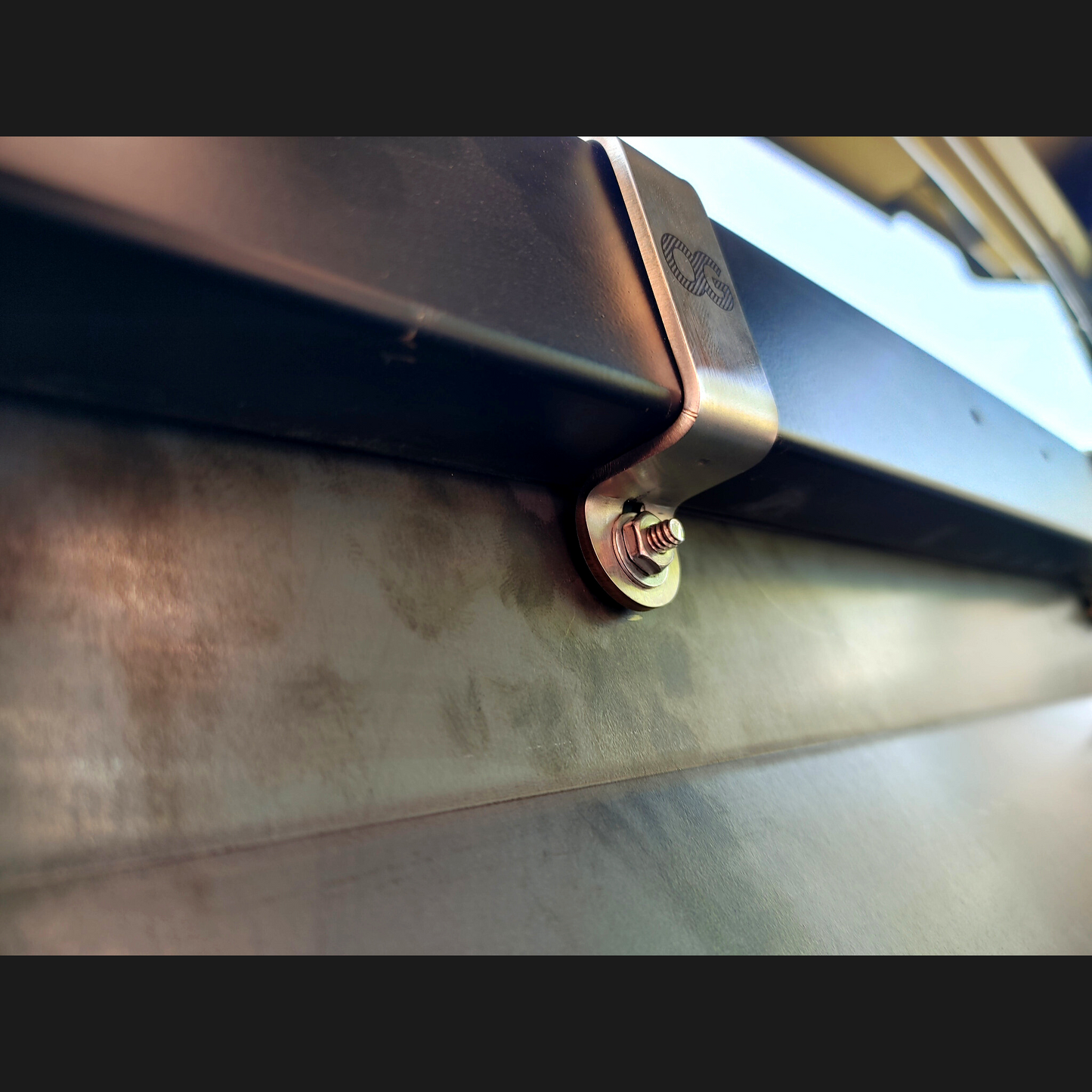 Close up view of an etched stainless steel mounting bracket for the OnlyGenerals rear lower filler panel kit