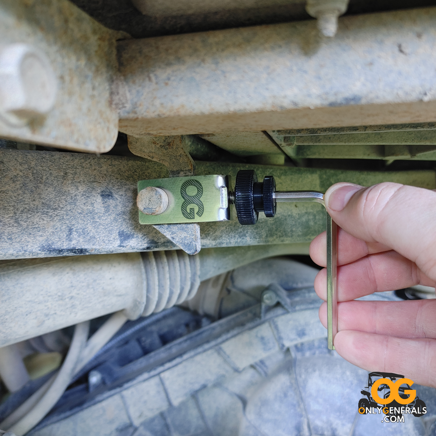 Hand using a tool on BedLocker Plus mechanical components with 'Only Generals' logo in the corner.