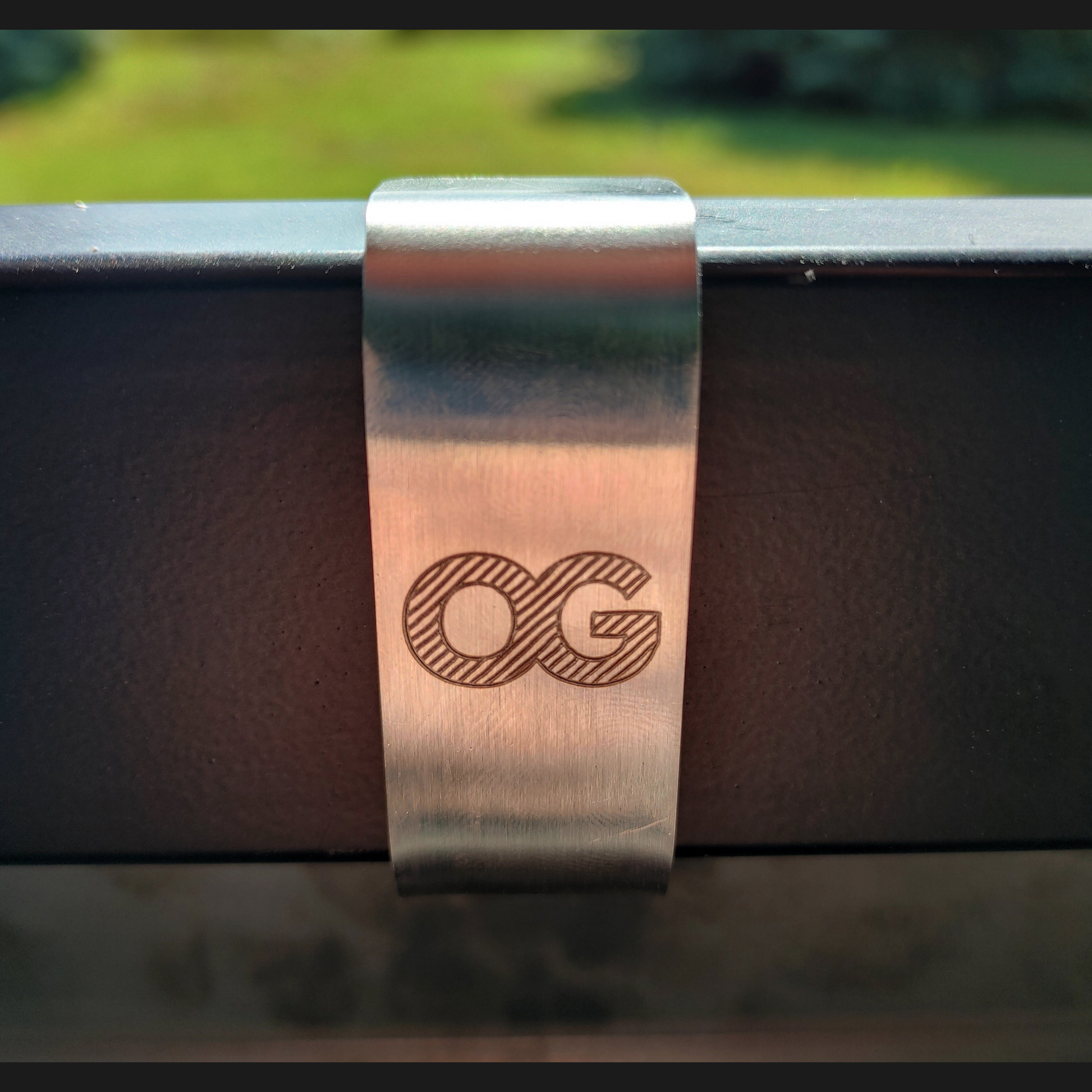 Laser etched OG logo on a stainless steel mounting bracket 